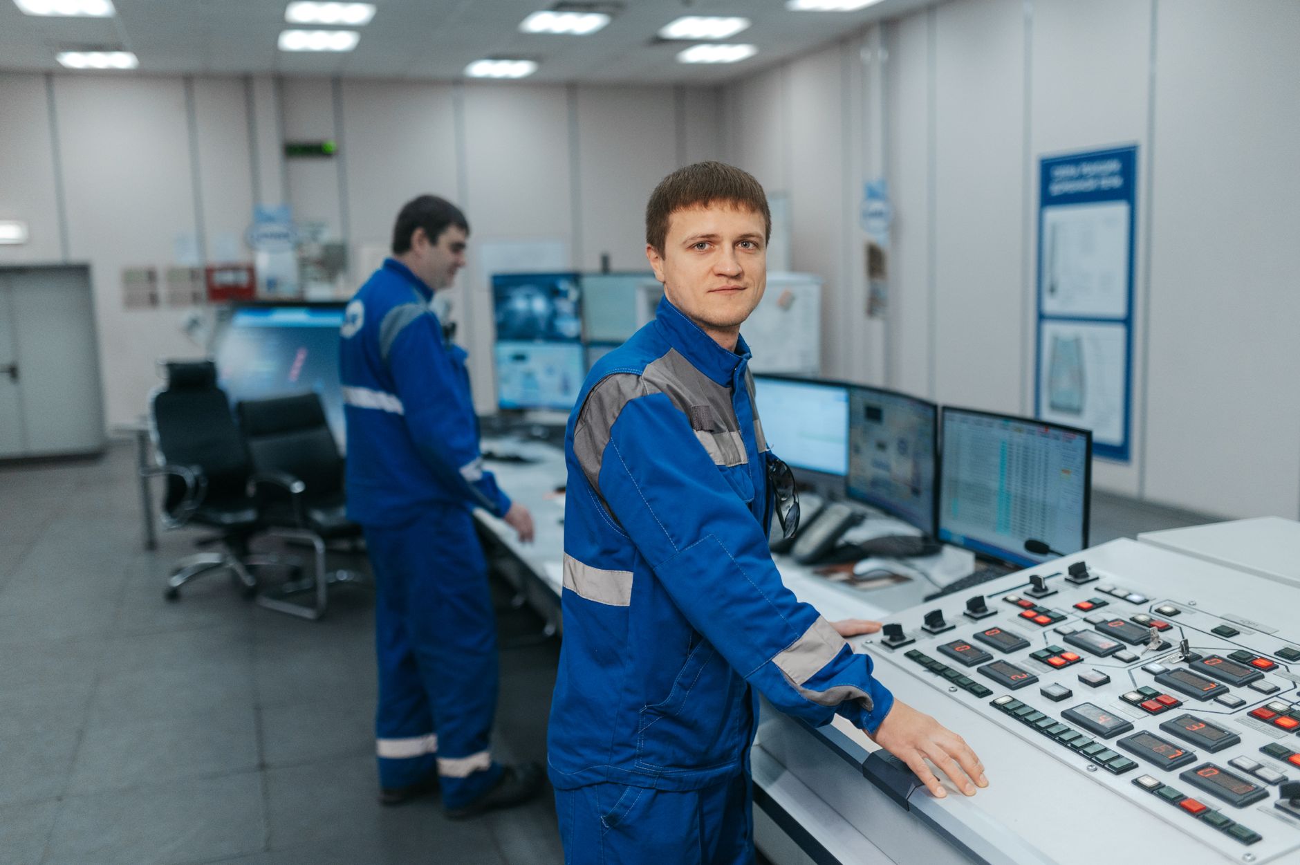 Technicians operating industrial control systems in a monitoring room