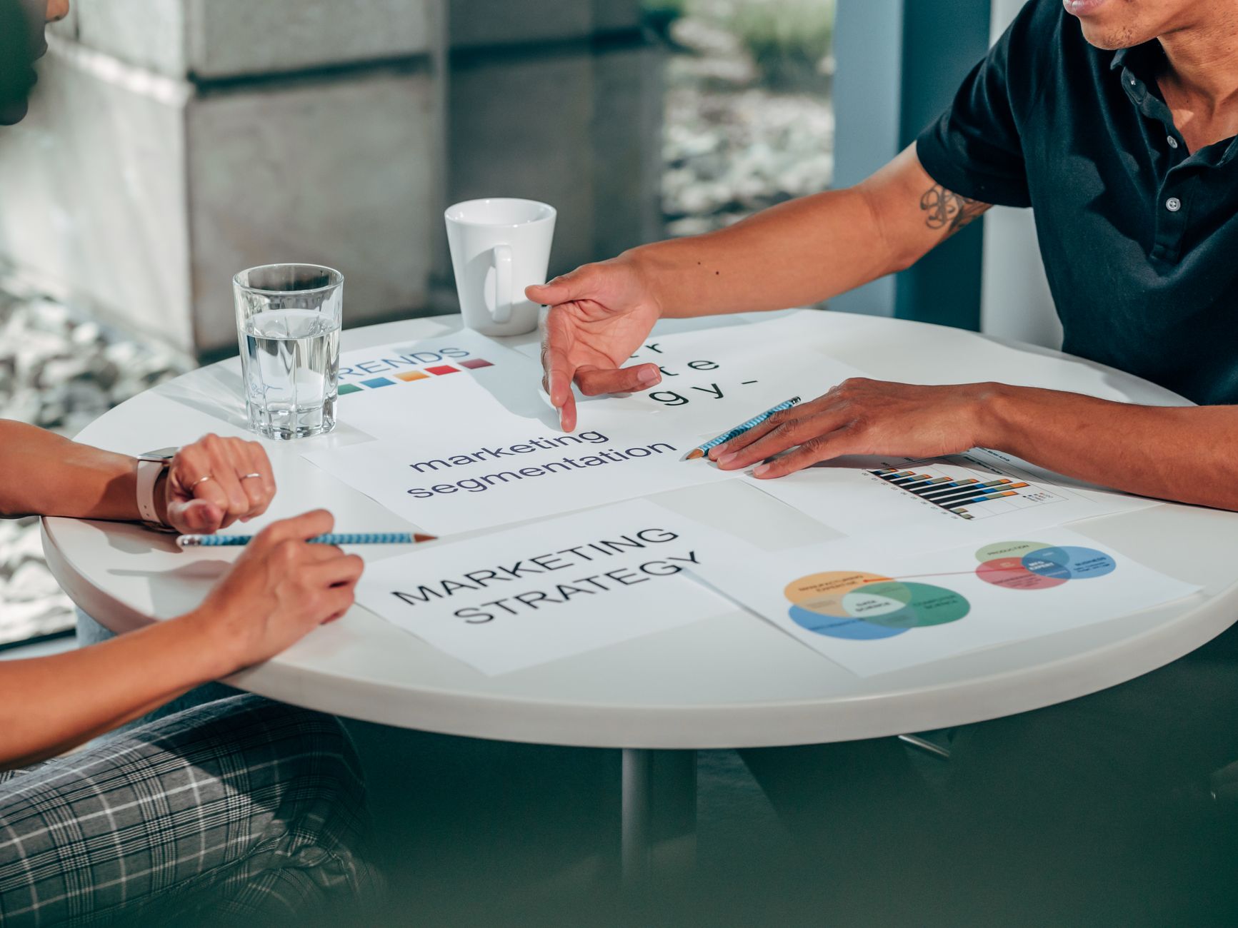 People reviewing strategy documents and workflow notes at a table
